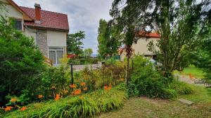 a garden with flowers in front of a house at Holiday home in Szantod - Balaton 43129 in Szántód