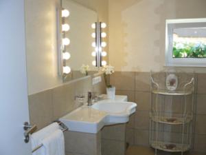 a bathroom with a sink and a mirror at Gästehaus Ina-Maria, Apartments in Obernhof