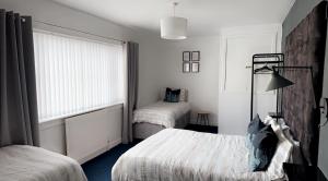 a hotel room with two beds and a window at Crown street getaway in Ayr