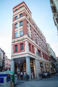 Un grand bâtiment avec des personnes assises à l'extérieur dans l'établissement Hostal Paris, à Valladolid