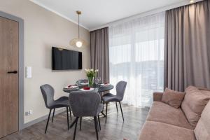 uma sala de estar com uma mesa e um sofá em Miedzyzdroje SEASIDE Apartments Bel Mare by Renters em Międzyzdroje