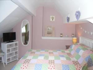 a bedroom with a bed and a tv in it at Claremont House Holiday Apartments in Llandudno