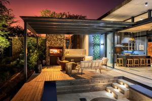 um pátio exterior com uma lareira e um sofá em Garangani 360 - Self-Catering Villa em Golders Green