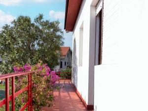 einen Balkon eines weißen Hauses mit rosa Blumen in der Unterkunft Charming holiday home in Sanxenxo with private terrace in Sanxenxo
