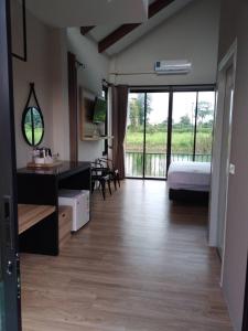 a bedroom with a bed and a desk and a bedroom with a balcony at Pailin Place in Chanthaburi