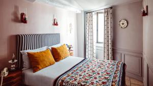 a bedroom with a bed with yellow pillows and a window at Maison Saintonge in Paris