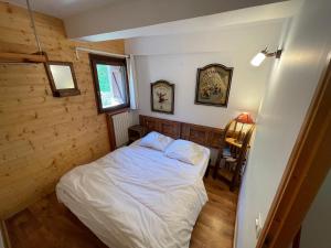 um quarto com uma cama num quarto com paredes de madeira em LE BLIZZARD Bel appartement avec grande terrasse dans vieille ferme de montagne rénovée em Les Orres