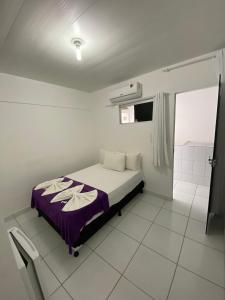 1 dormitorio con 1 cama con manta morada en Pousada Vela Mar, en Maragogi