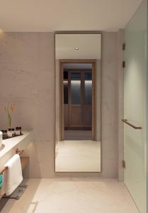 a bathroom with a wooden door and a mirror at Mitsis Summer Palace in Kardamaina