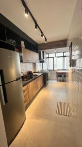 a kitchen with a stainless steel refrigerator and a table at Beira Mar na José Menino in Santos