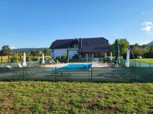 a fence in front of a house with a pool at Villa Stone 1 in Rakovica