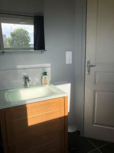 baño con lavabo blanco y ventana en Le logis du Chesnot, en Saint-Quentin-sur-le-Homme