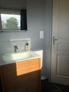baño con lavabo blanco y ventana en Le logis du Chesnot en Saint-Quentin-sur-le-Homme