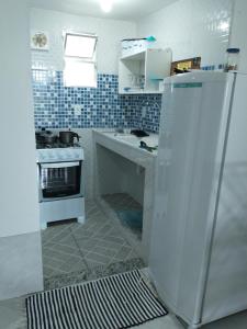 una piccola cucina con piano cottura e frigorifero di Pousada do Veleiro Azul ad Angra dos Reis