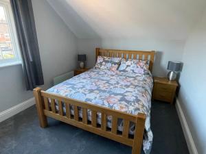 a bedroom with a bed with a floral bedspread at The Up And Over in Northallerton