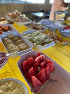 una mesa cubierta con bandejas de sandía y otros alimentos en Pousada Vela Mar, en Maragogi