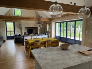 uma cozinha e sala de estar com mesa e cadeiras em La Rigottiere em Huismes