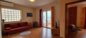 a living room with a red couch and a television at Apartment Nikola in Jelsa