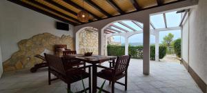 a dining room with a table and chairs on a patio at Apartment Nikola in Jelsa