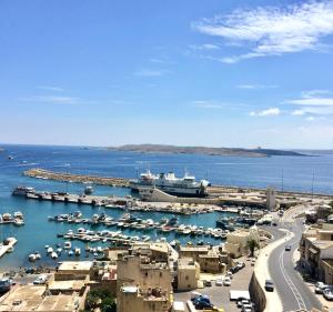a harbor with boats and a cruise ship in the water at Seafront Apartment with Balcony Overlooking Marina in Għajnsielem