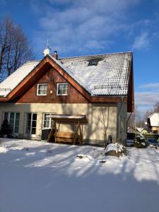 dom ze śniegiem na ziemi przed nim w obiekcie Dom Pod Sosną w mieście Karpacz