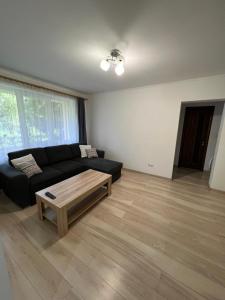 ein Wohnzimmer mit einem schwarzen Sofa und einem Couchtisch in der Unterkunft Gold Apartments in Baia Mare