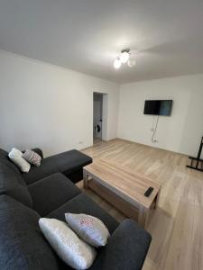 ein Wohnzimmer mit 2 Sofas und einem Couchtisch in der Unterkunft Gold Apartments in Baia Mare