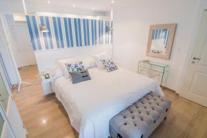 1 dormitorio con 1 cama blanca grande con almohadas azules en Estudio en zona centro de Granada, en Granada