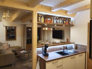 a kitchen with a sink and a living room at Hochalmbahnen Chalets 13W1, Ulme, nahe Gondel, Hunde willkommen in Rauris