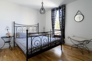 a bedroom with a black bed and a chair at Les Terrasses de la Vallée in Champs-Sur-Marne