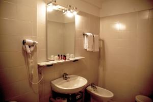 La salle de bains est pourvue d'un lavabo, d'un miroir et de toilettes. dans l'établissement Auberge De La Madone, à Peillon