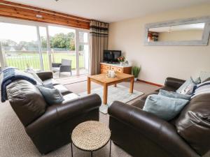 ein Wohnzimmer mit 2 Ledersofas und einem TV in der Unterkunft Patch's Place in Gunnislake
