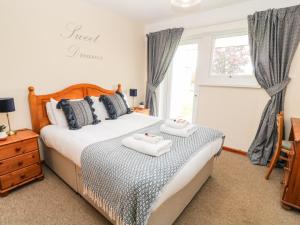 ein Schlafzimmer mit einem Bett mit zwei Handtüchern darauf in der Unterkunft Patch's Place in Gunnislake
