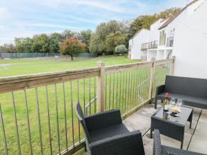 eine Terrasse mit 2 Stühlen und einem Tisch mit einem Feld in der Unterkunft Patch's Place in Gunnislake
