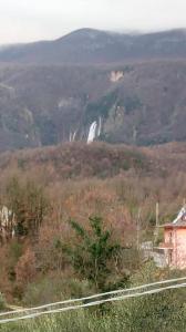 a waterfall in the middle of a mountain with a house at Faber B&B - Riserva Naturale Zompo lo Schioppo in Morino