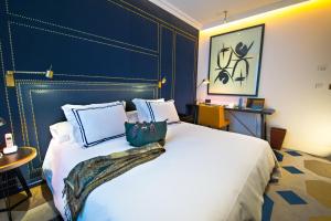 a bedroom with a large white bed with a blue headboard at Only YOU Boutique Hotel Madrid in Madrid