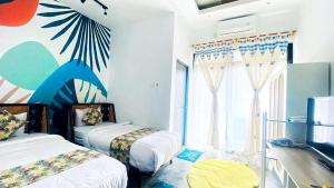 a bedroom with two beds and a large window at PALAGAN HUIS in Kejayan