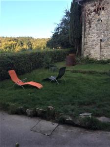 zwei Stühle im Gras im Garten in der Unterkunft L'hôte des voyageurs en pays limousin 1 