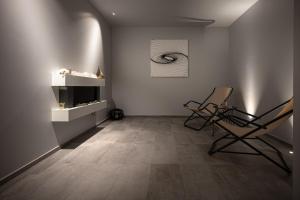 een woonkamer met 2 stoelen en een muur met een foto bij Hotel Cristal in Sirmione