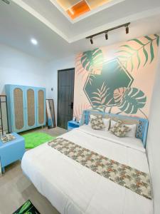 a bedroom with a white bed and a colorful wall at PALAGAN HUIS in Kejayan