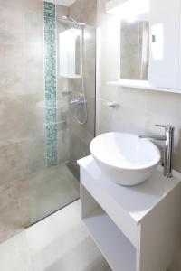 a white bathroom with a sink and a shower at GARAY 29- Depto un dormitorio in Santa Fe