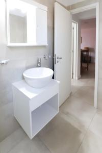 a white bathroom with a sink and a mirror at GARAY 29- Depto un dormitorio in Santa Fe +2 photos