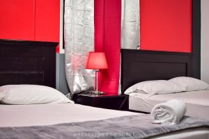 two beds in a room with red walls at Diesbu Hotel in Marcala