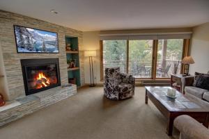 ein Wohnzimmer mit einem Kamin und einem TV in der Unterkunft Ski Run 201 in Keystone
