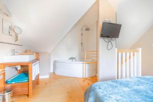 um quarto com uma casa de banho com um lavatório e uma banheira em Cottages à proximité de la plage em Dinard
