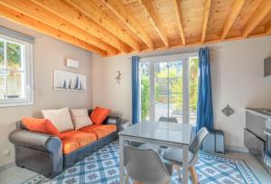 uma sala de estar com um sofá e uma mesa em Cottages à proximité de la plage em Dinard