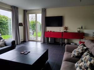 een woonkamer met een bank en een tafel bij Vakantiehuis in Knokke-Heist met tuin en parkeerplaats in Knokke-Heist