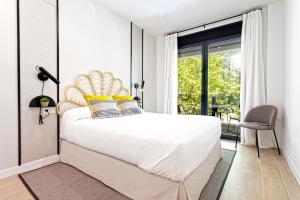 um quarto com uma grande cama branca com almofadas amarelas em Genteel Home Arruzafa em Córdoba