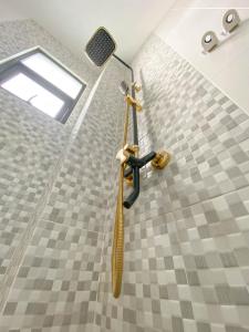 a shower in a bathroom with a shower head at PALAGAN HUIS in Kejayan