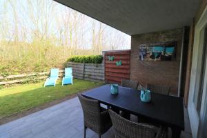 una mesa negra y sillas en un patio en Schorrebloem 10, en Nieuwvliet